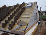 Roof is felt and battened, gable wall is built with velux, and roof is loaded with new tiles